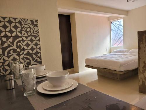 a room with a bed and a table with dishes on it at D-07 NOVAGA DOWNTOWN CANCUN in Cancún