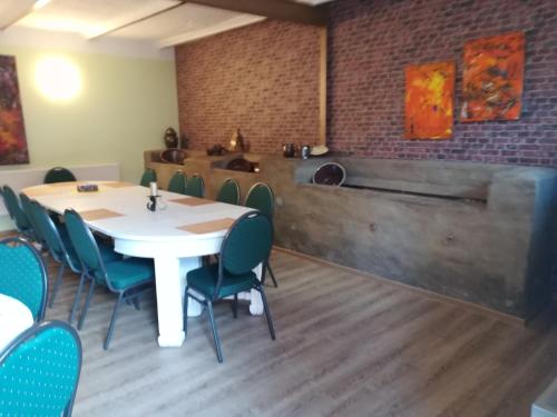 a dining room with a white table and chairs at Pension Claudia Güldenpfennig in Tangermünde