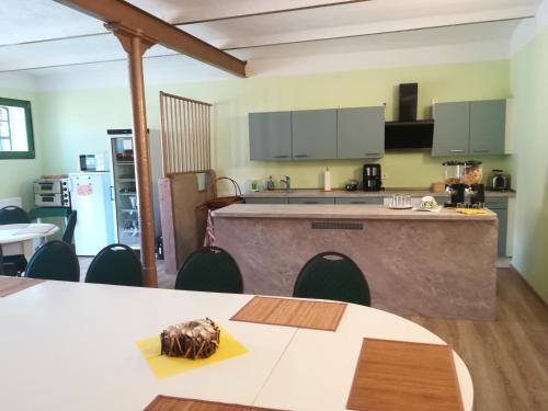 a kitchen with a counter and a table with chairs at Pension Claudia Güldenpfennig in Tangermünde