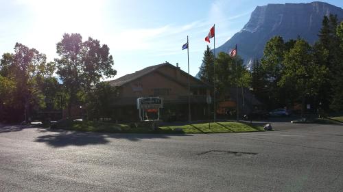 a building with two flags and a mountain in the background at Douglas Fir Resort & Chalets in Banff