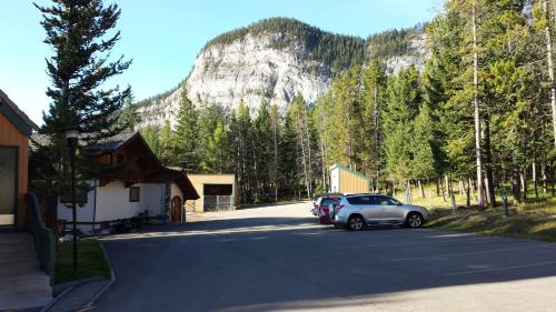 a parking lot with cars parked in front of a mountain at Douglas Fir Resort & Chalets in Banff