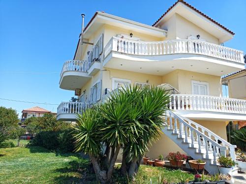 a house with white balconies and a palm tree at Villa Dani in Aigio
