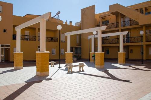 un patio de un edificio con columnas y bancos blancos en Apartamento Tarifa Sol, en Tarifa