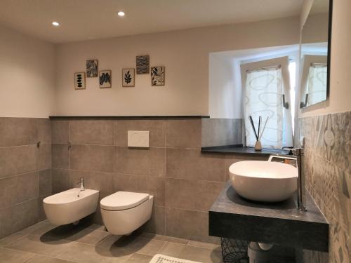 a bathroom with a toilet and a bidet and a sink at Appartamento CADELAVE in Villa di Chiavenna