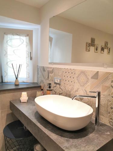 a large white tub in a bathroom with a mirror at Appartamento CADELAVE in Villa di Chiavenna