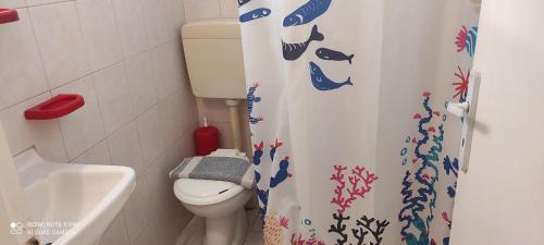 a bathroom with a toilet and a shower curtain at Loukia Apartments & Studios in Naousa