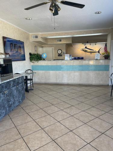eine Restaurant-Lobby mit einer Theke und einer Bar in der Unterkunft Hole Inn the Wall Hotel - Fort Walton Beach - Sunset Plaza - nearby Beaches & Hurlburt in Fort Walton Beach