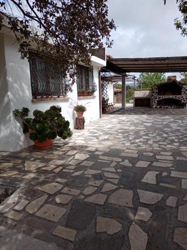 a courtyard with a stone floor and a building at VILLA LUPINO in Orosei