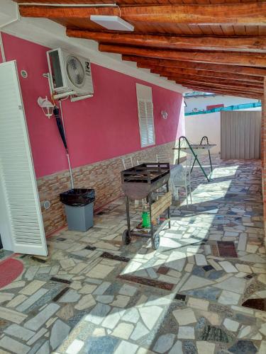 a room with a stone floor and a pink wall at New Summer Apartment in Agnone Bagni