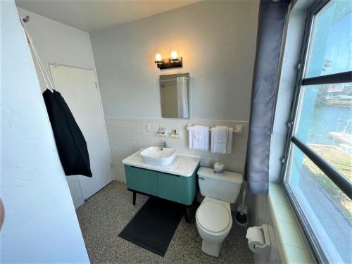 a bathroom with a white toilet and a sink at Sea Jay Motel and Marina in St Pete Beach