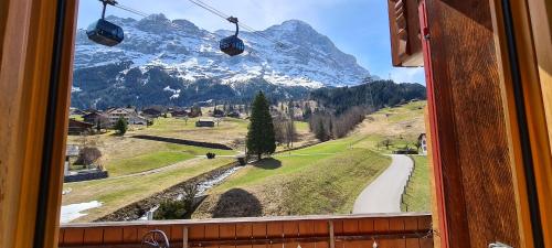 a view of a snow covered mountain from a window at Chalet Bodenwald in Grindelwald