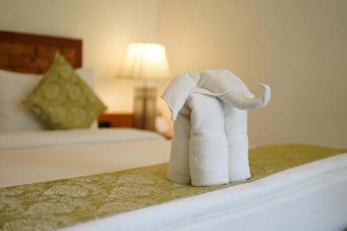a towel elephant on a bed in a hotel room at Saraca Resort & Spa Corbett in Garjia