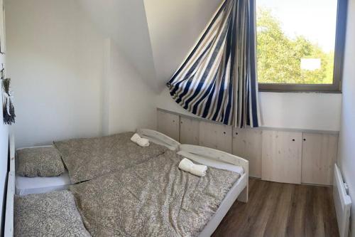a bedroom with two beds and a window at Tündérrózsa vendégház in Tahitótfalu