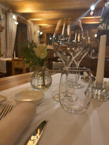 una mesa con copas de vino en un mantel blanco en La Luge, en Valtournenche