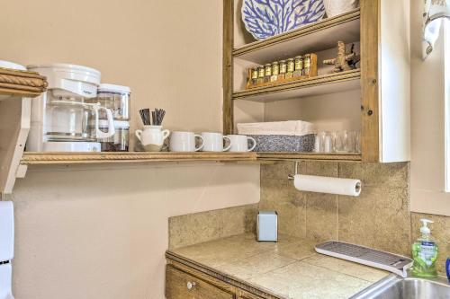 a kitchen with a sink and a shelf with dishes at Cozy BeachandFishing Cottage in Aransas Pass! in Aransas Pass