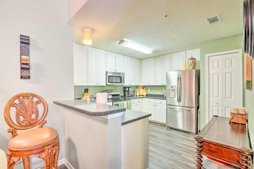 a kitchen with white cabinets and a stainless steel refrigerator at Cheery Condo with Community Pool and Waterslide! in Pine Bluff