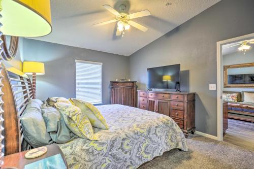 a bedroom with a bed and a flat screen tv at Cheery Condo with Community Pool and Waterslide! in Pine Bluff