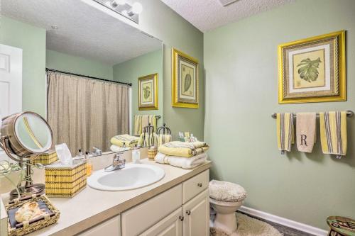 a bathroom with a sink and a mirror at Cheery Condo with Community Pool and Waterslide! in Pine Bluff