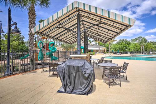 a patio with a table and chairs next to a pool at Cheery Condo with Community Pool and Waterslide! in Pine Bluff