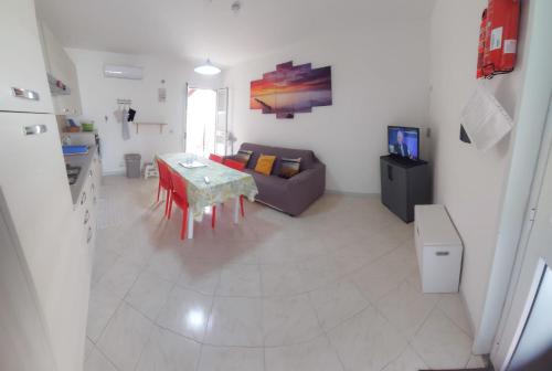 a living room with a table and a couch at New Summer Apartment in Agnone Bagni