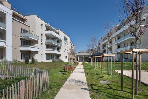 an apartment building with a playground in front of it at DOMITYS LES TOURMALINES in Carpentras