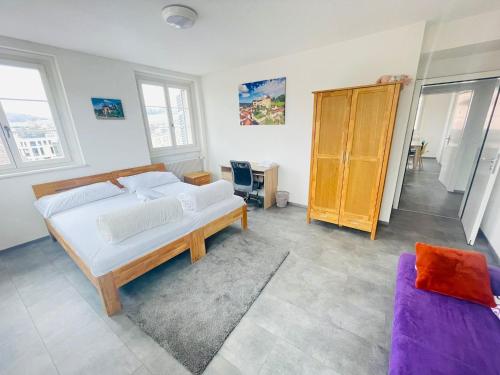 een slaapkamer met een groot bed en een bank bij The 5 continents III - Premium appartment by Stay Swiss in Porrentruy