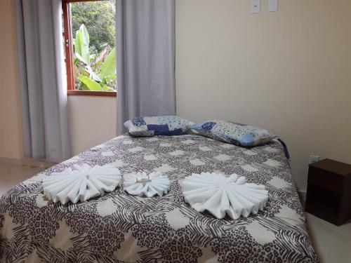 een slaapkamer met een bed met kussens erop bij Casa Aconchego visconde de Mauá in Itatiaia