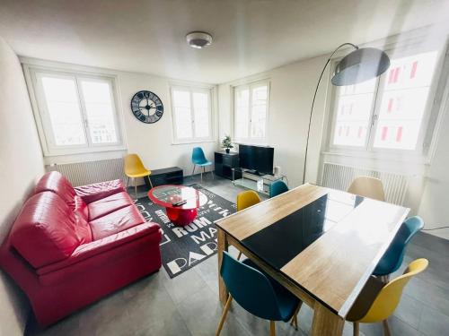 a living room with a red couch and a table at The 5 continents III by Stay Swiss in Porrentruy