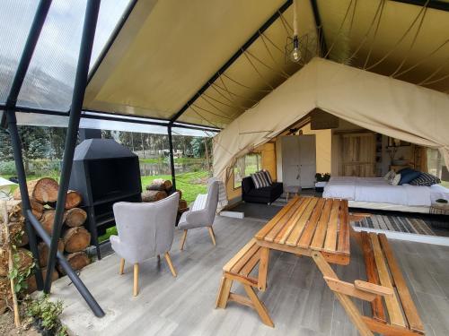 a tent with a bed and a tv and a table at Palumbo Glamping & Villas in Cayambe