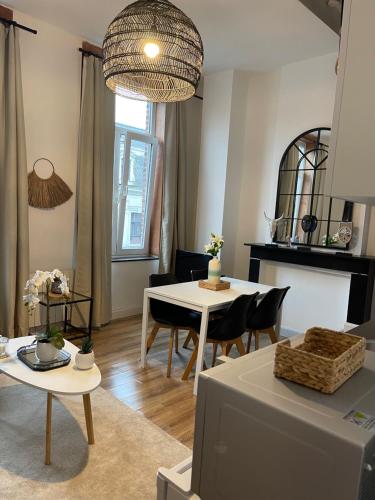 uma sala de estar com uma mesa branca e cadeiras em residence rogier afri em Mons