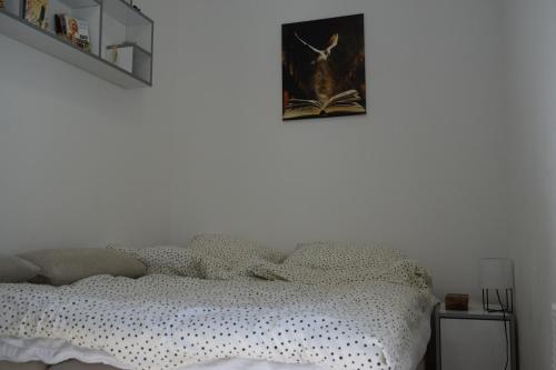 a bedroom with a bed and a picture on the wall at Apartmani K&V in Veliko Gradište