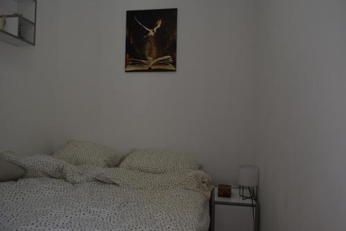 a bedroom with a bed and a picture on the wall at Apartmani K&V in Veliko Gradište