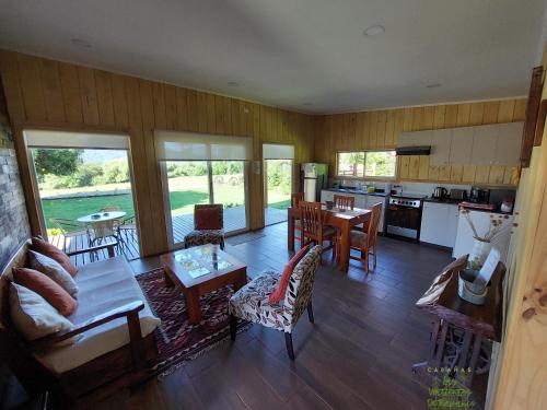 cocina y sala de estar con mesa y sillas en Cabañas Las Vertientes de Rupanco, en Puerto Octay