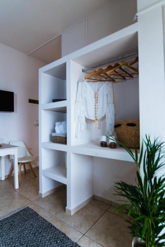 a white closet with a white shirt hanging on it at Le Palme in Malia