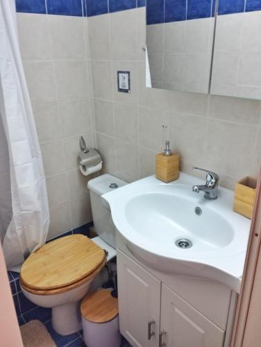 a bathroom with a white sink and a toilet at CozyCoast in Rafina