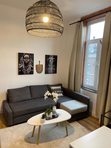 - un salon avec un canapé et une table dans l'établissement residence rogier afri, à Mons