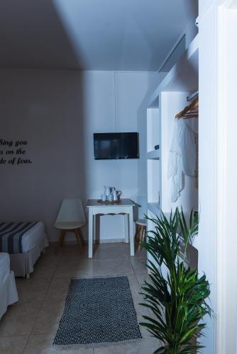 a room with a table and a tv on a wall at Le Palme in Malia