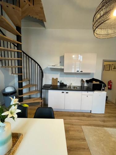 uma cozinha com armários brancos e uma escadaria em residence rogier afri em Mons