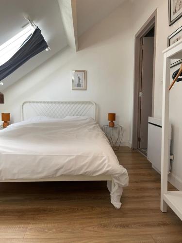 - une chambre avec un lit blanc et du parquet dans l'établissement residence rogier afri, à Mons