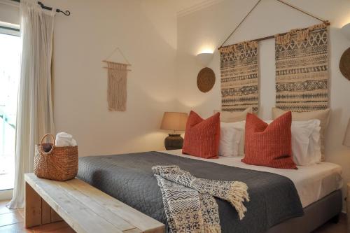 a bedroom with a large bed with red pillows at 2BR Duplex Townhouse with access to Pool - 5mn to Beach by LovelyStay in Ferragudo