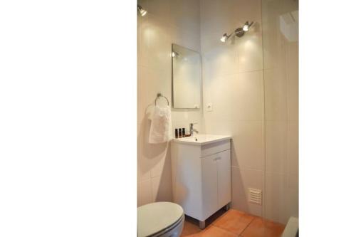 a bathroom with a toilet and a sink and a mirror at 2BR Duplex Townhouse with access to Pool - 5mn to Beach by LovelyStay in Ferragudo