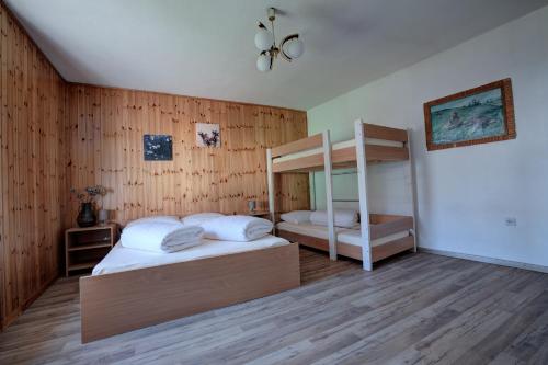 Apartma Hči planin في بوفيك: سريرين في غرفة بجدران خشبية