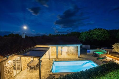 a house with a swimming pool at night at Villa Larra in Gostinjac