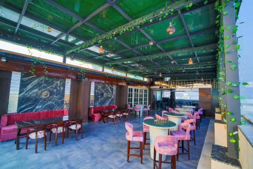 a restaurant with tables and chairs and a green ceiling at Hotel Holy Vivasa in Rishīkesh