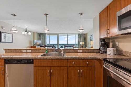 a kitchen with wooden cabinets and a sink and a counter top at Sandy Beach Resort in Myrtle Beach