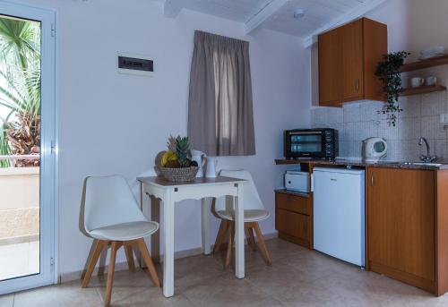 a small kitchen with a table and a microwave at Le Palme in Malia