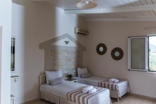 a white room with two beds and a window at Le Palme in Malia