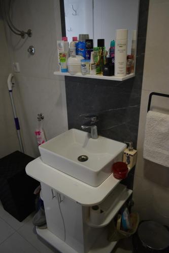 a bathroom with a white sink and shelves at Apartmani K&V in Veliko Gradište
