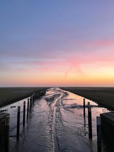 a view of a body of water at sunset at Ferienwohnung „Deichgeflüster“ nahe der Nordsee in Marne