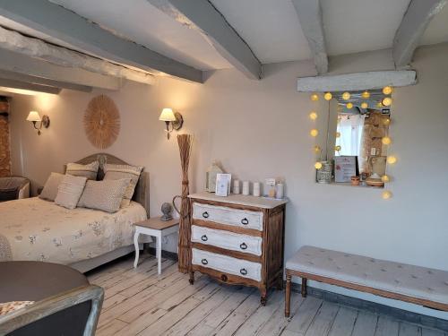 a bedroom with a bed and a dresser and a mirror at Le Clos Des Etoiles in Le Bugue